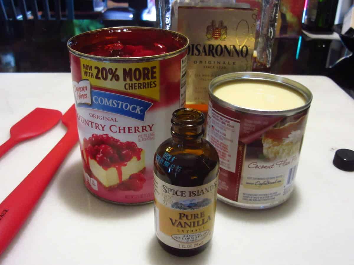 Cherry pie filling, vanilla, sweetened condensed milk, and amaretto on the counter for making no churn ice cream.