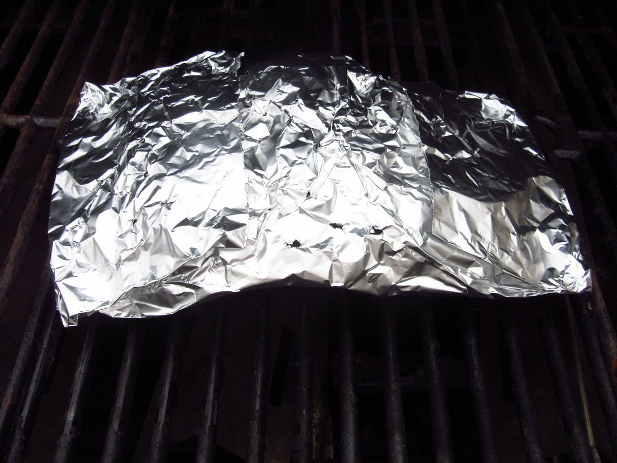 A packet of foil on outdoor grill grates.
