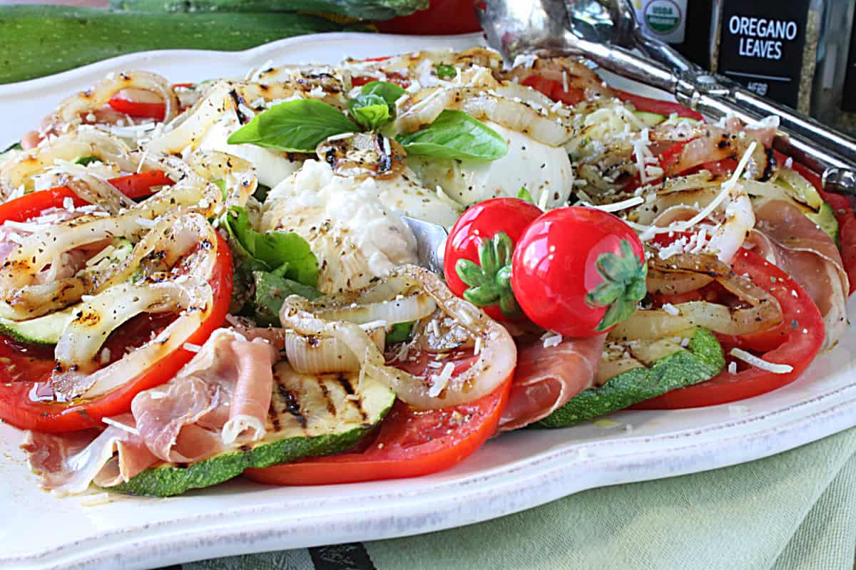 A tri-color Caprese Salad with red, white, and green on a pretty platter.
