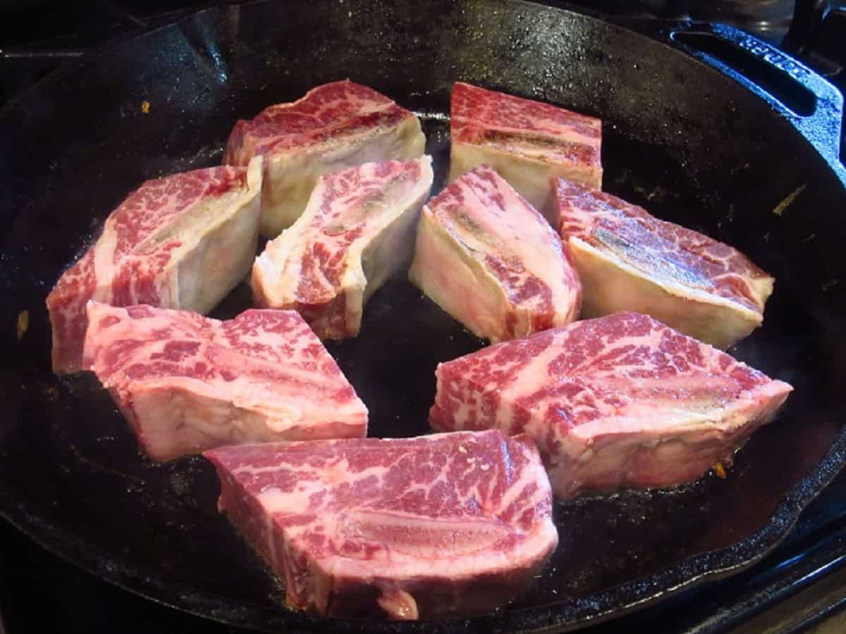 Short ribs in a cast iron skillet.