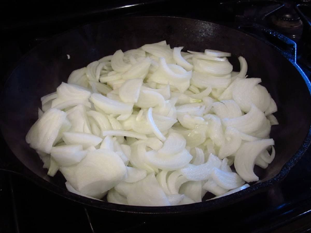 Cut onions in a cast iron skillet.