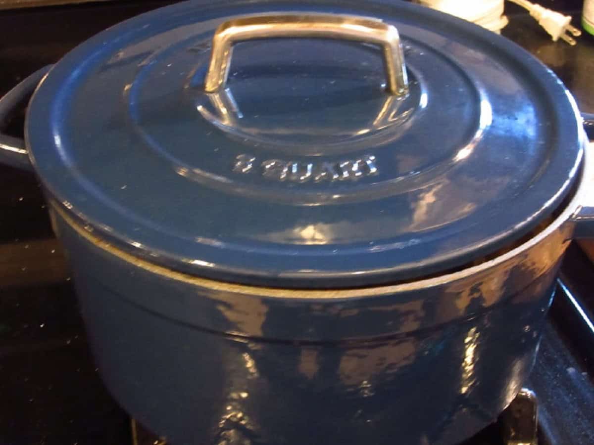 A blue Dutch oven on the stovetop.