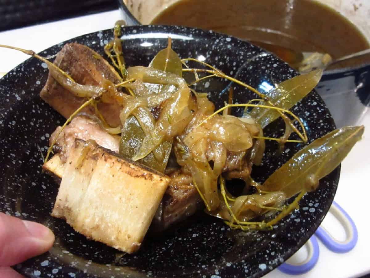 Cooked bones and bay leaves in a bowl.