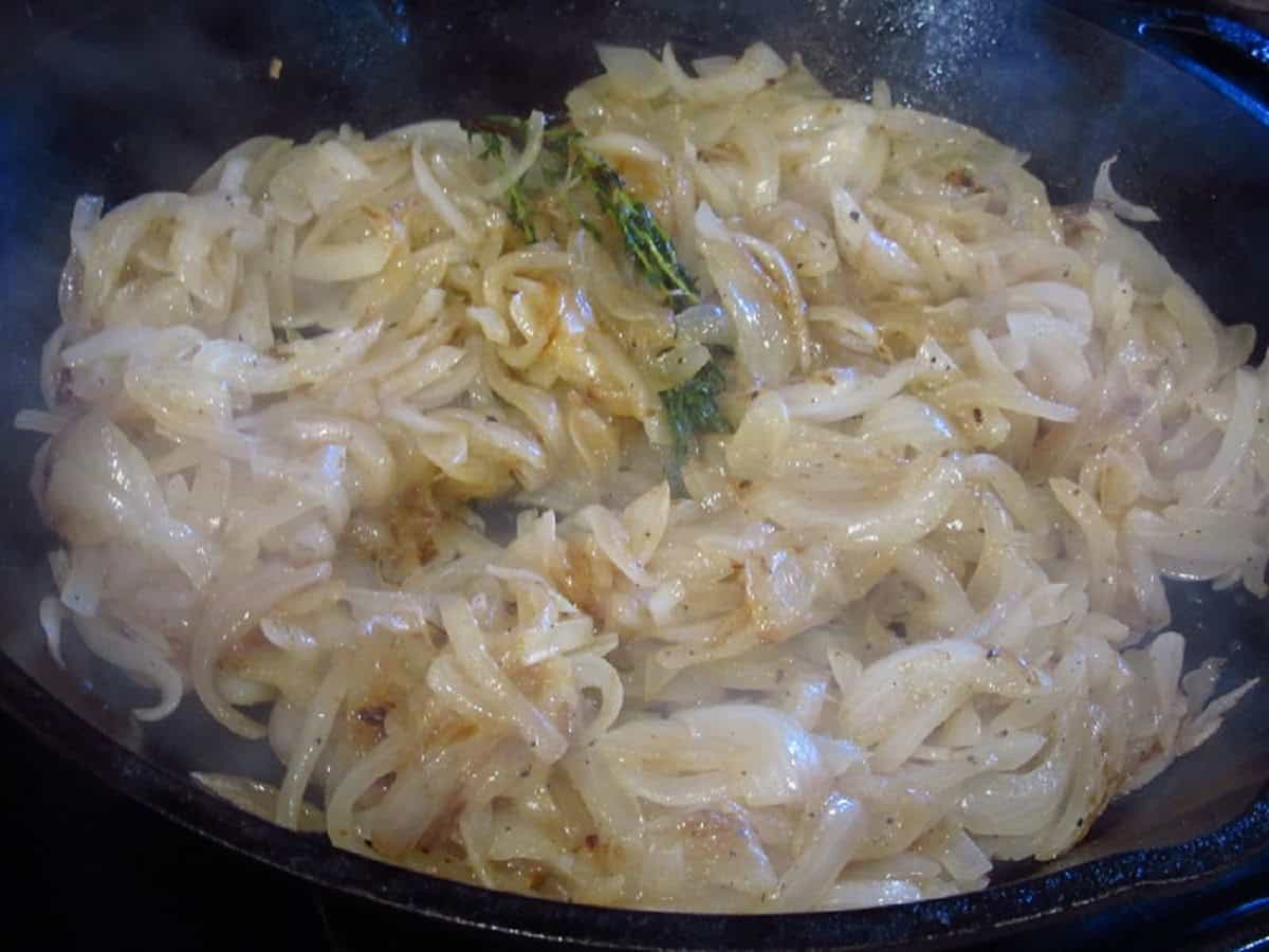 Caramelizing onions in a cast iron skillet with thyme.