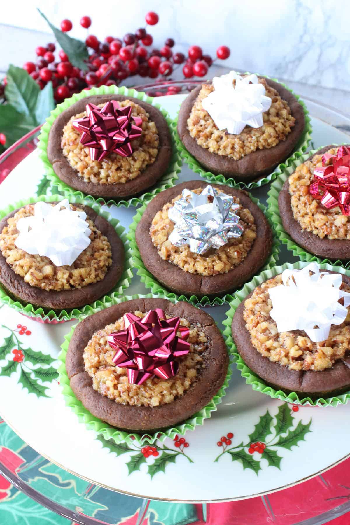 Pretty Gingerbread Pecan Pie Tarts on a holly berry plate for Christmas.
