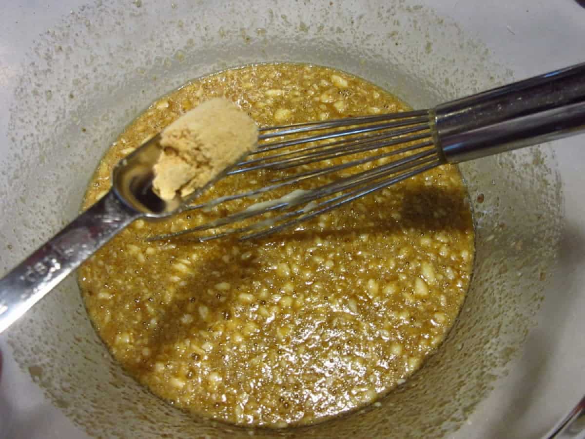 Dry ginger being added to pecan pie filling.
