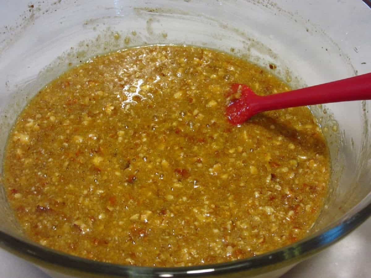 Pecan pie filling in a glass bowl with a spatula.