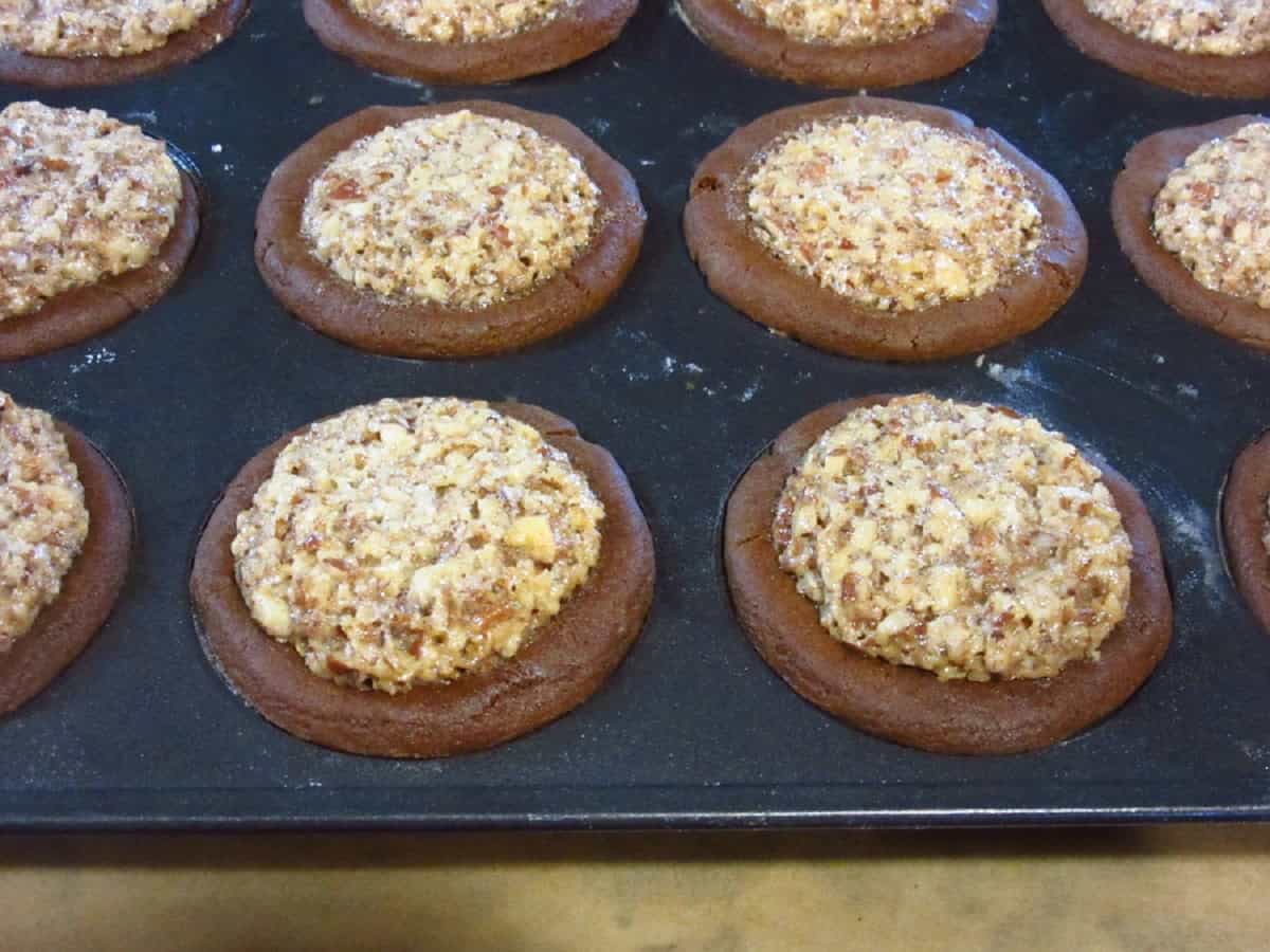 Puffed and baked Gingerbread Pecan Pie Tarts in a muffin tin.