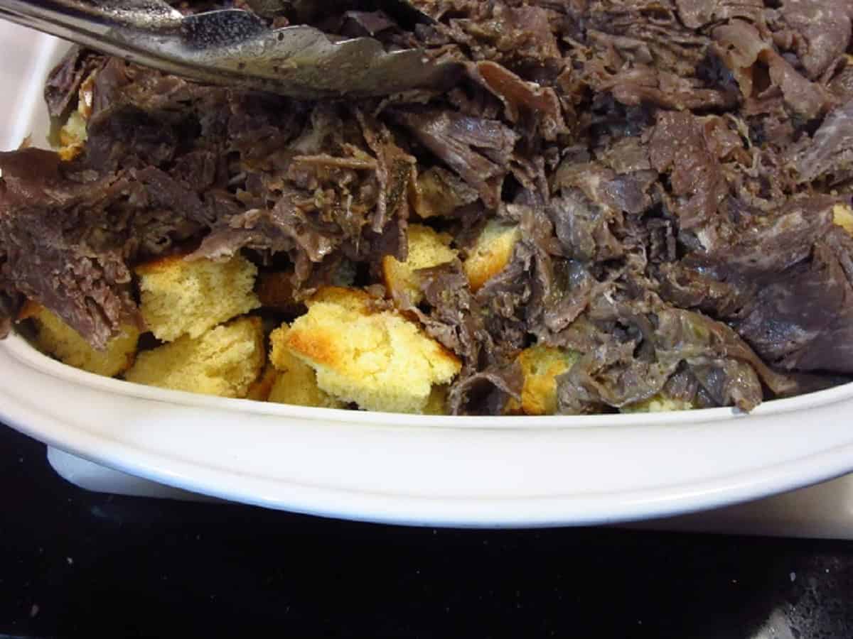 Bread and Italian beef in a casserole dish.