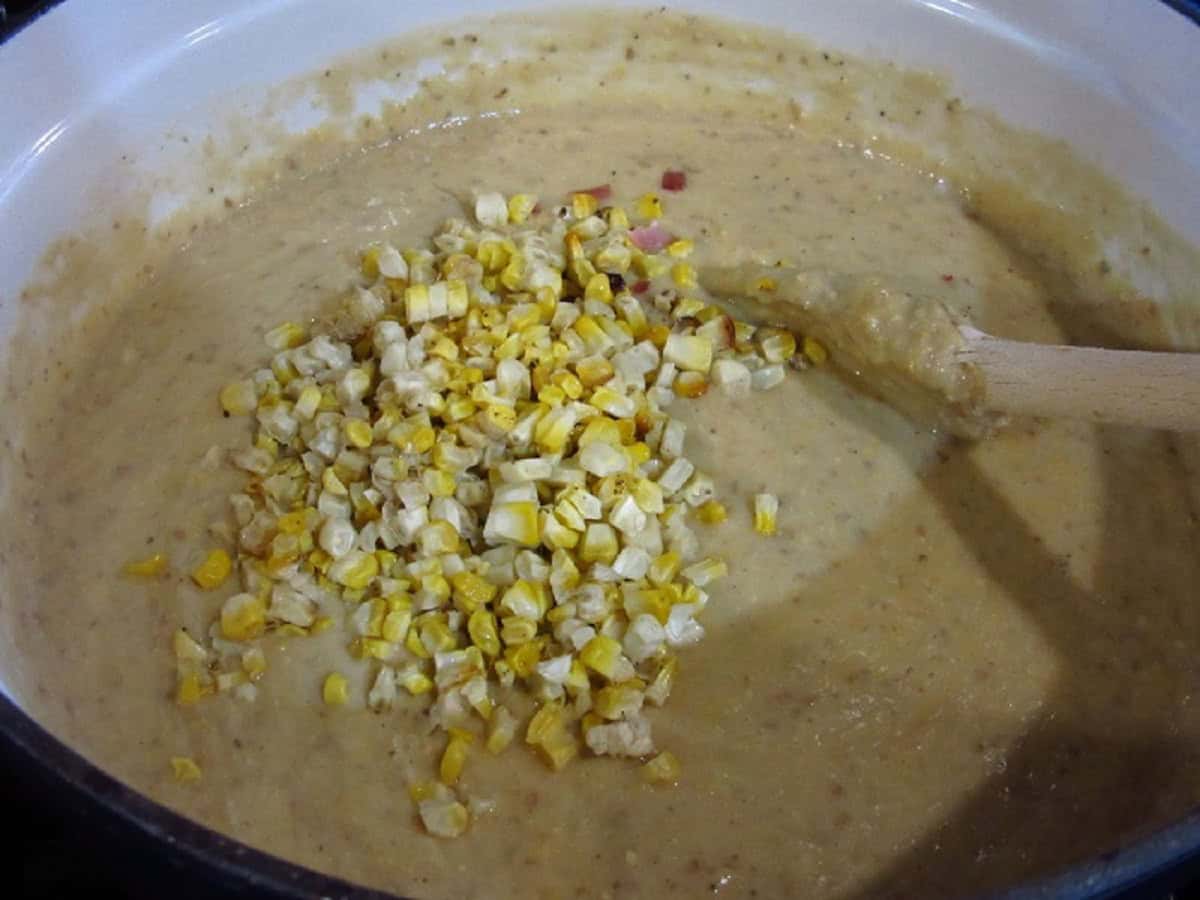 Corn kernels added to a Dutch oven of corn chowder.