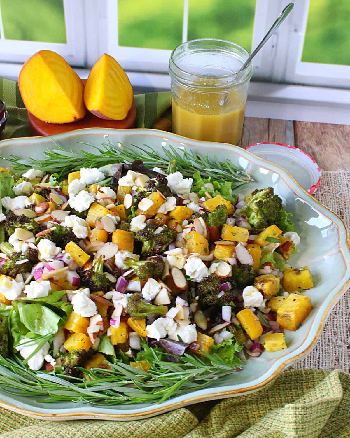 Roasted Golden Beet and Broccoli Salad A large platter filled with Roasted Golden Beet and Broccoli Salad along with rosemary sprigs and goat's cheese.