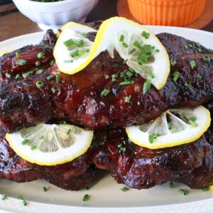 Lemon slices and chopped chives on top of beautiful spicy hot BBQ country pork ribs.