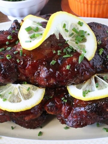 Lemon slices and chopped chives on top of beautiful spicy hot BBQ country pork ribs.
