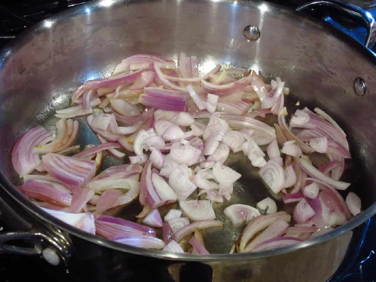 Sliced shallots in a large skillet.