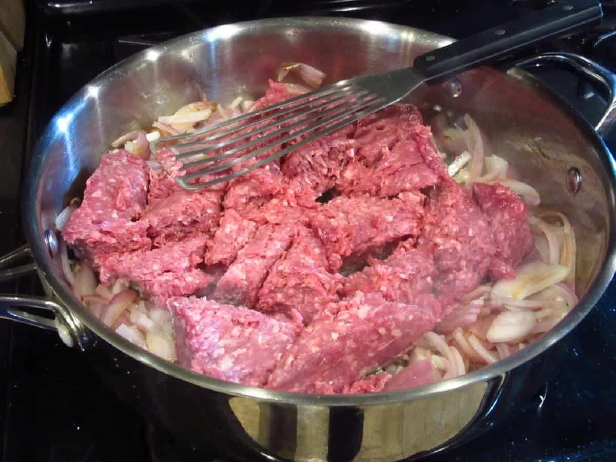 Ground beef in a large skillet with shallots before browning.