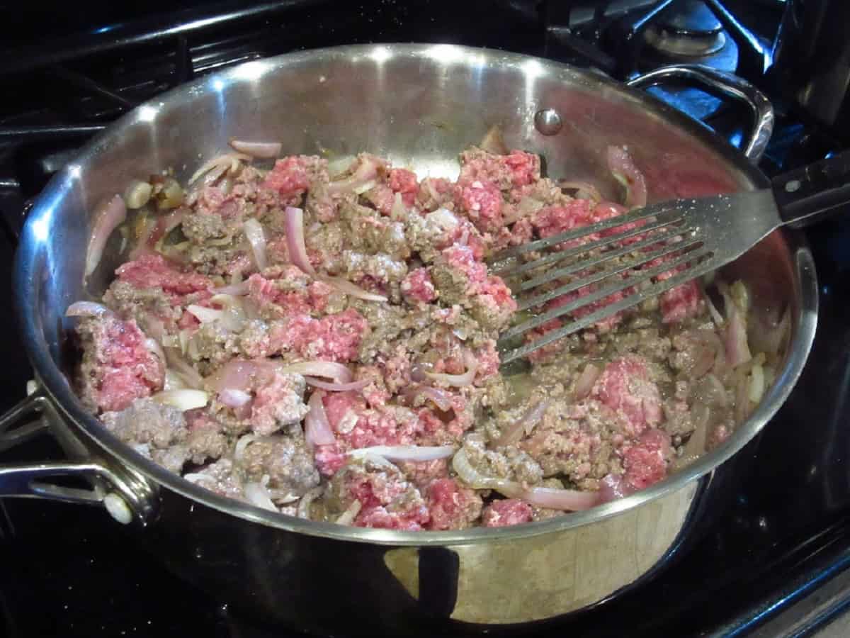 Browning ground beef with shallots in a large skillet.