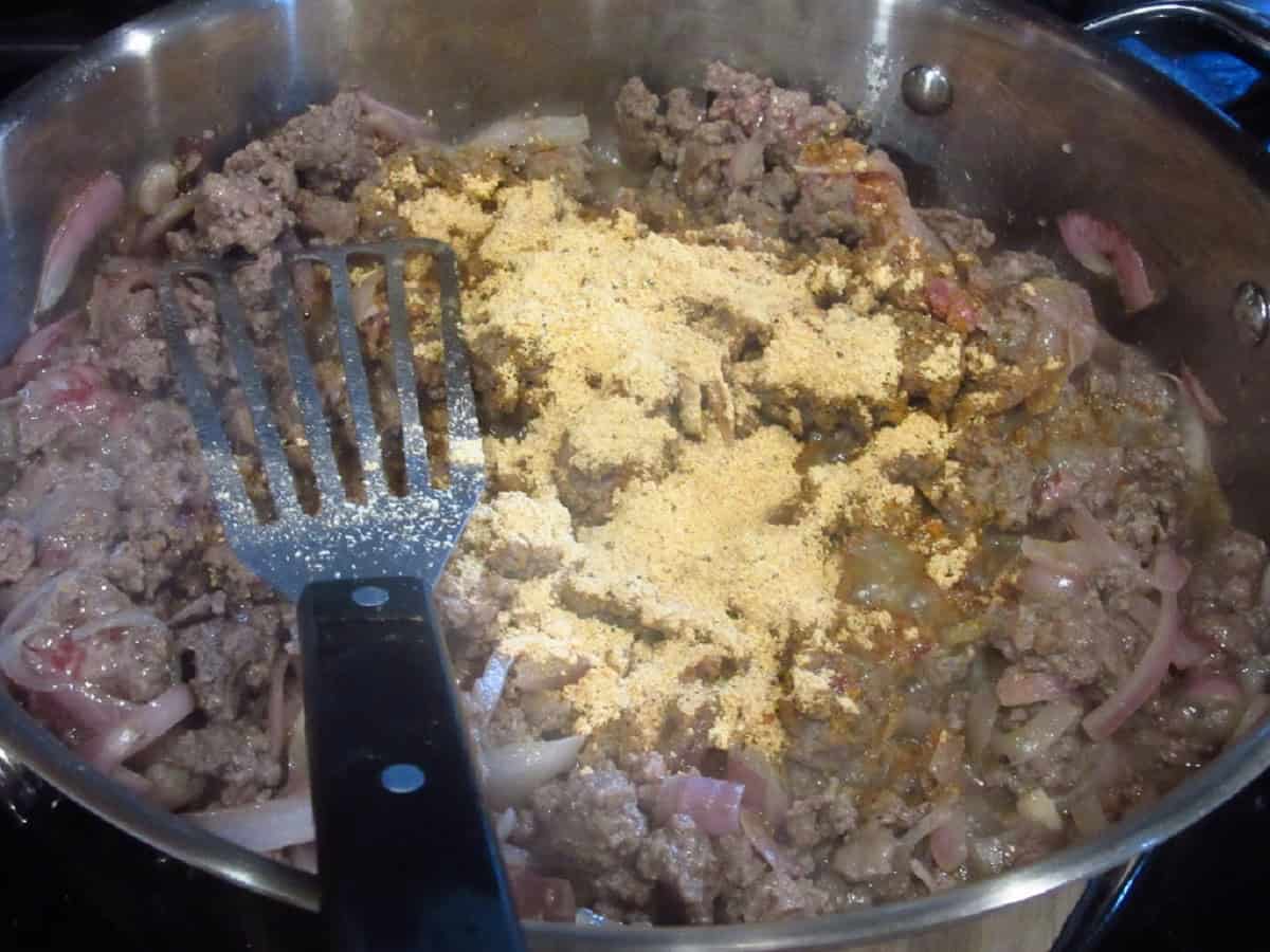 Dry sauerbraten mix added to a skillet with ground beef and shallots.