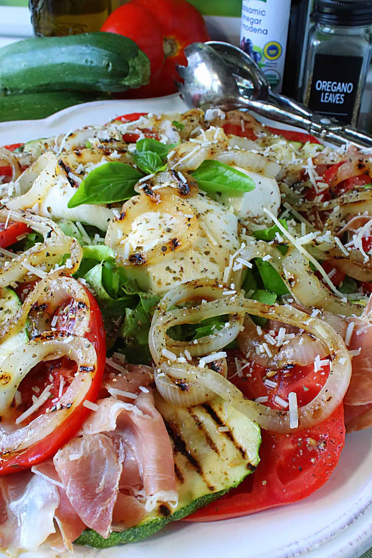 Fresh basil on top of the ultimate Caprese Salad with burrata, prosciutto, and zucchini.