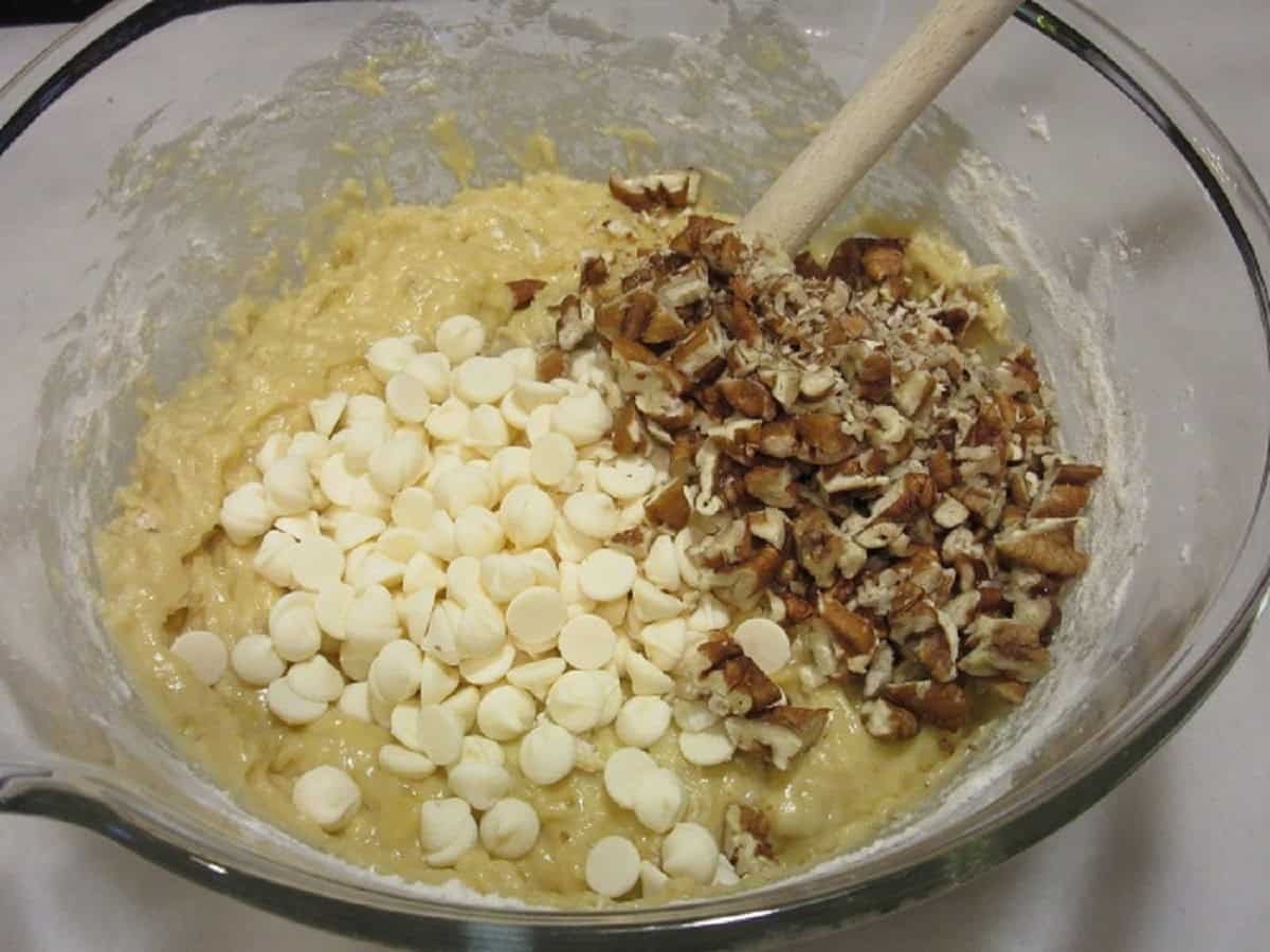 White chocolate chips with pecans in a banana bread batter.