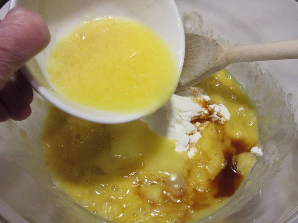 Melted butter being added to a mixing bowl for banana bread.