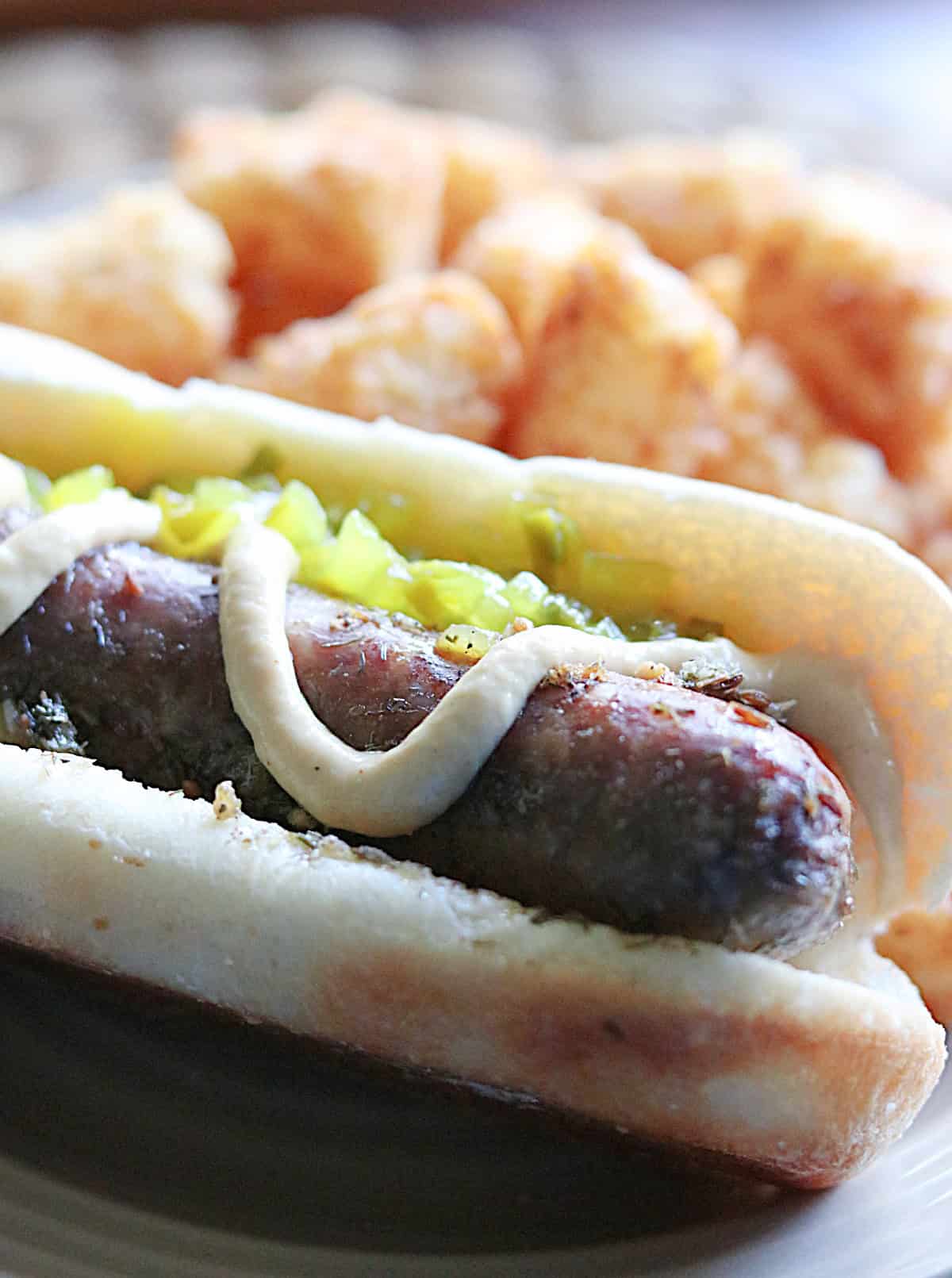 A beer braised bratwurst in a bun with mustard and relish.