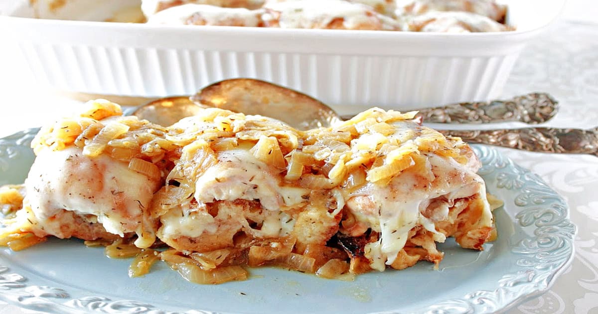 A blue platter filled with cheese topped French Onion Chicken Thighs.