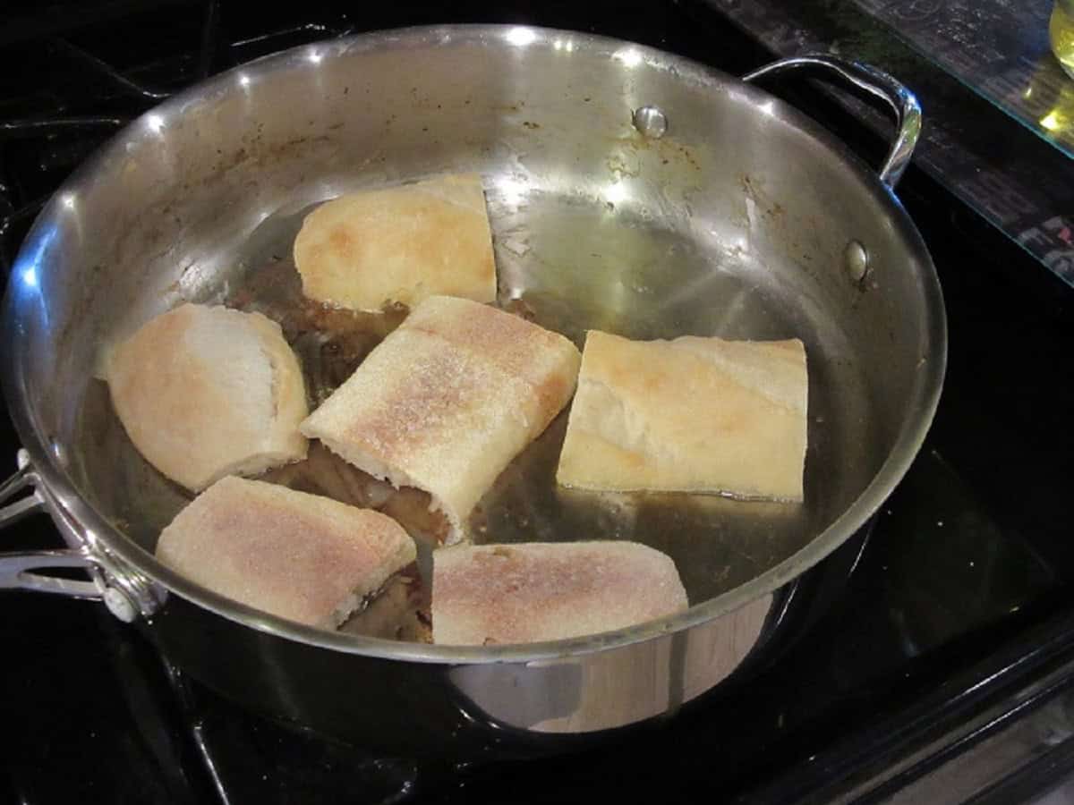 Toasting French bread in a large skillet with butter and oil.