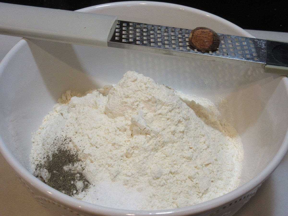 Fresh nutmeg being grated into the dry ingredients for making spaetzle.