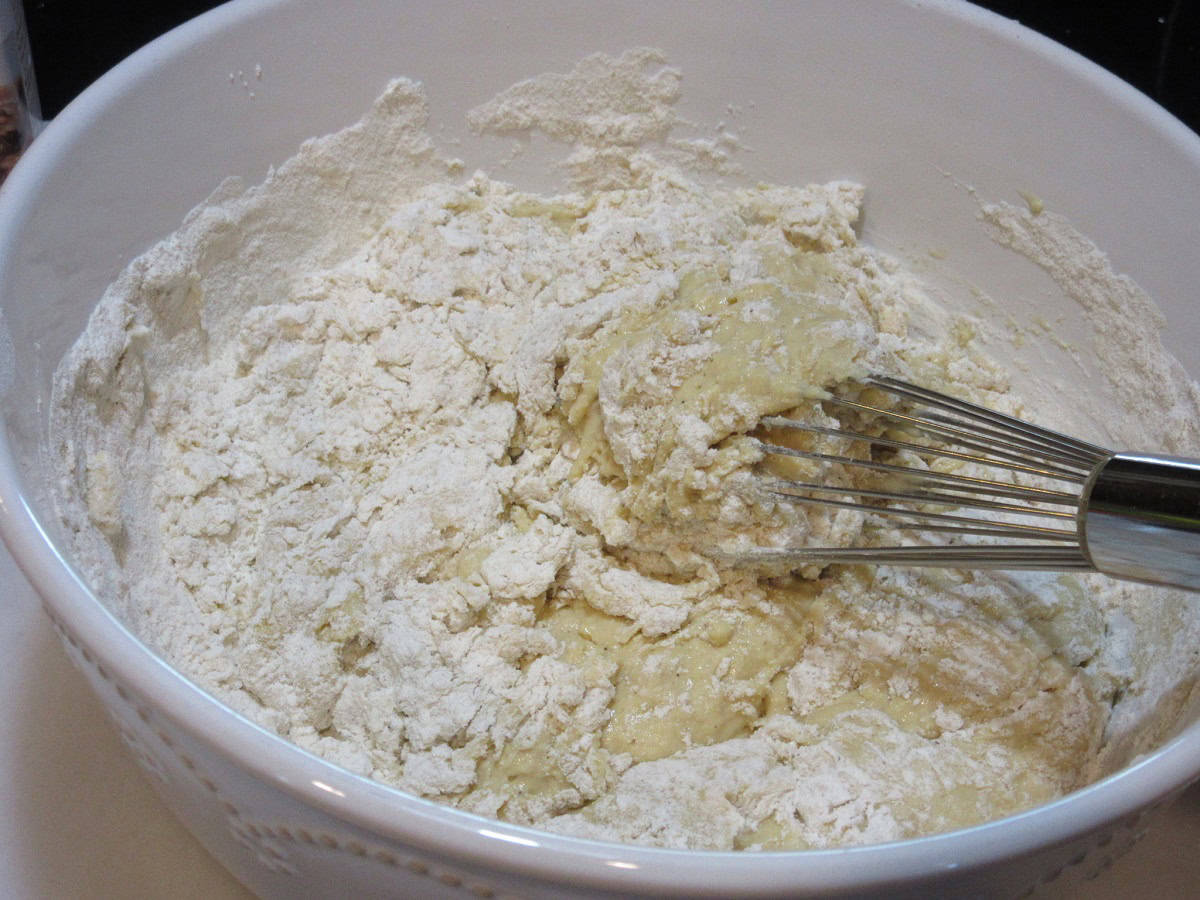 Spaetzle dough in a white bowl with a whisk.