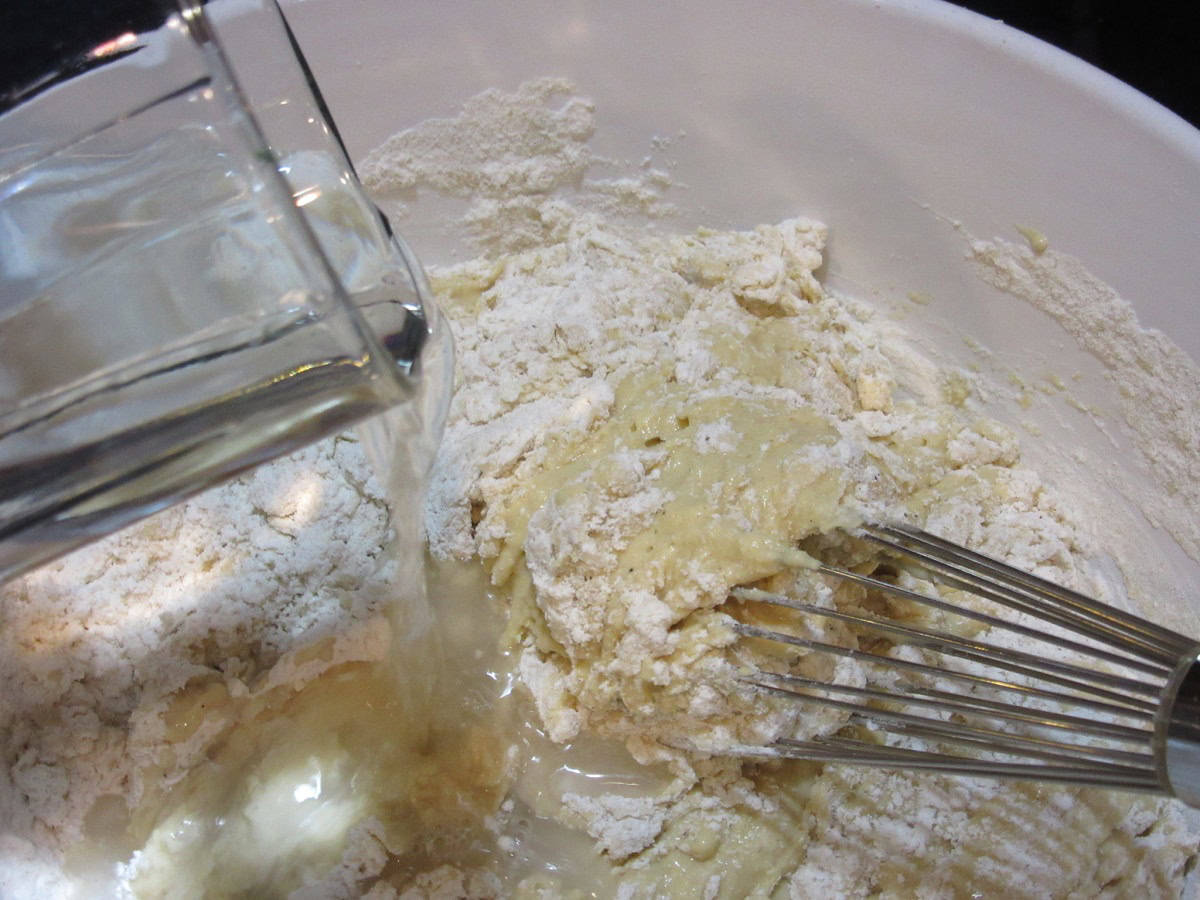Making spaetzle dough in a bowl with a whisk.