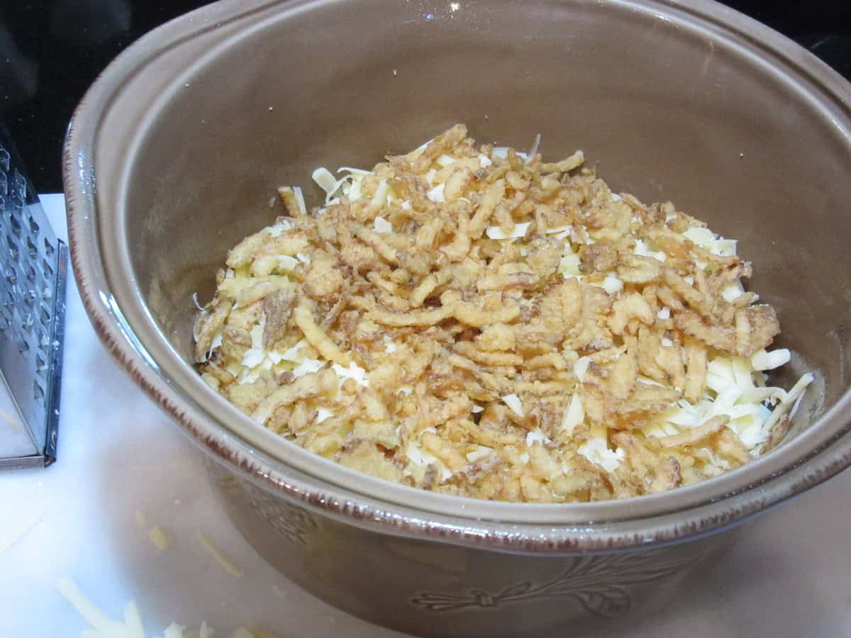 Laying a German spaetzle casserole with ingredients.