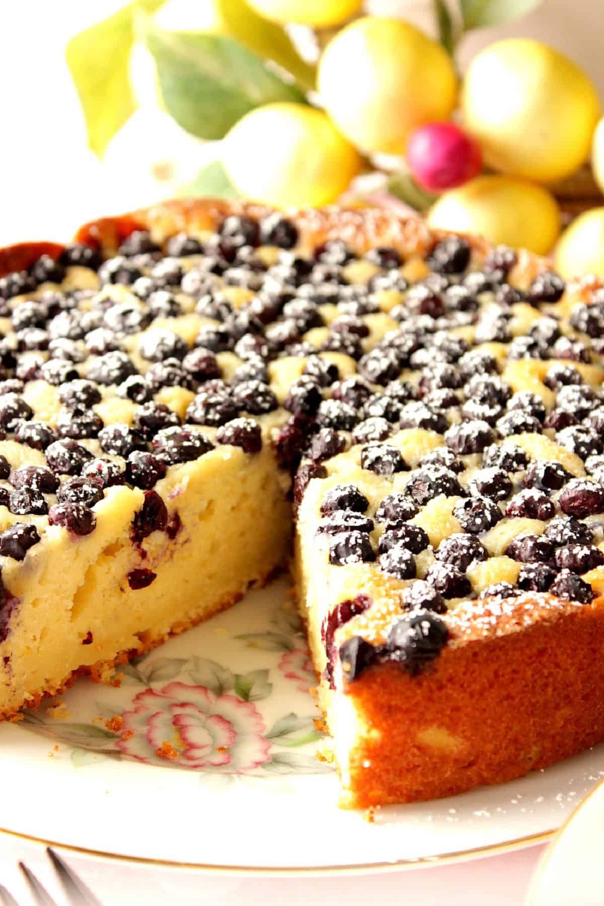 An lemon ricotta cake with a slice taken out.