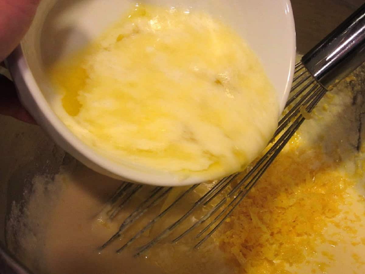 Melted butter being poured into a cake batter.