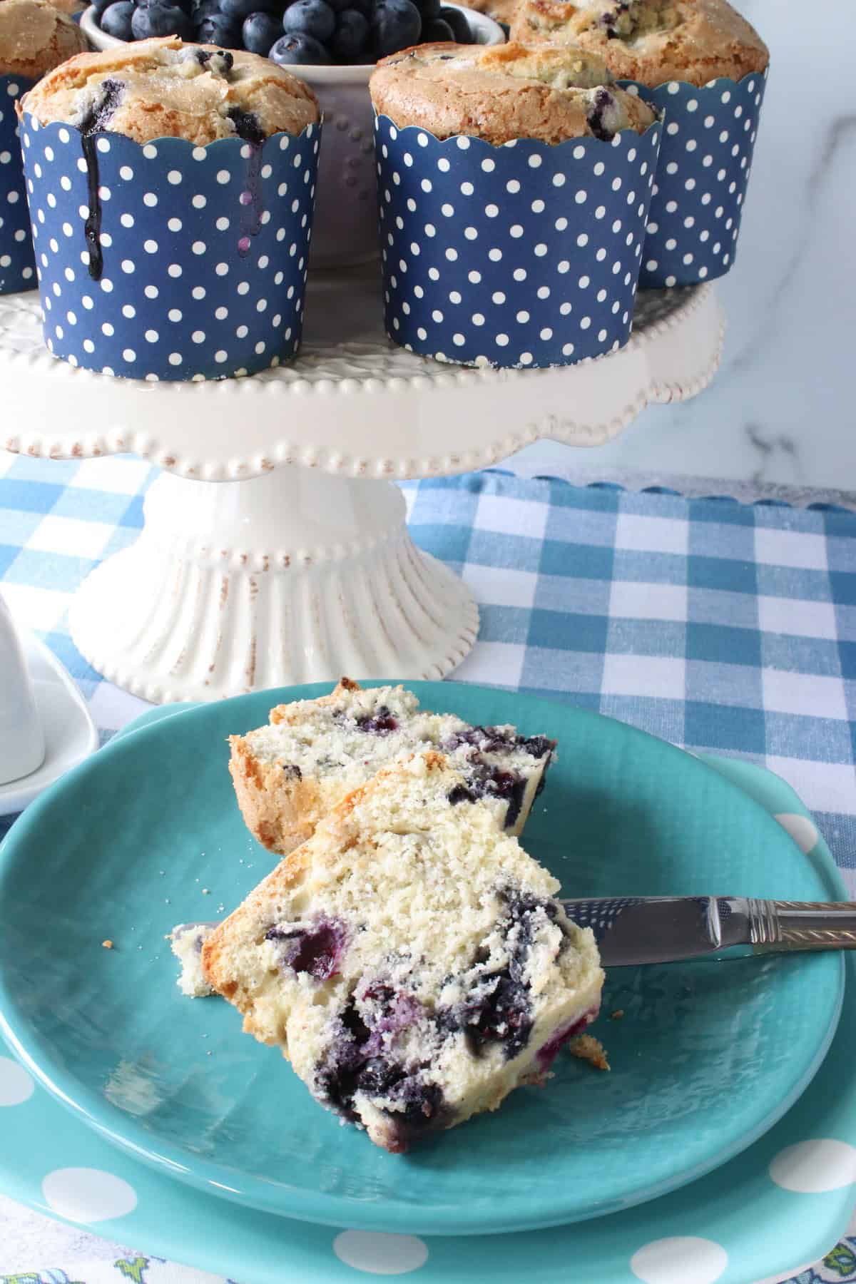 The inside of a blueberry muffin which has been cut in half on a blue plate.