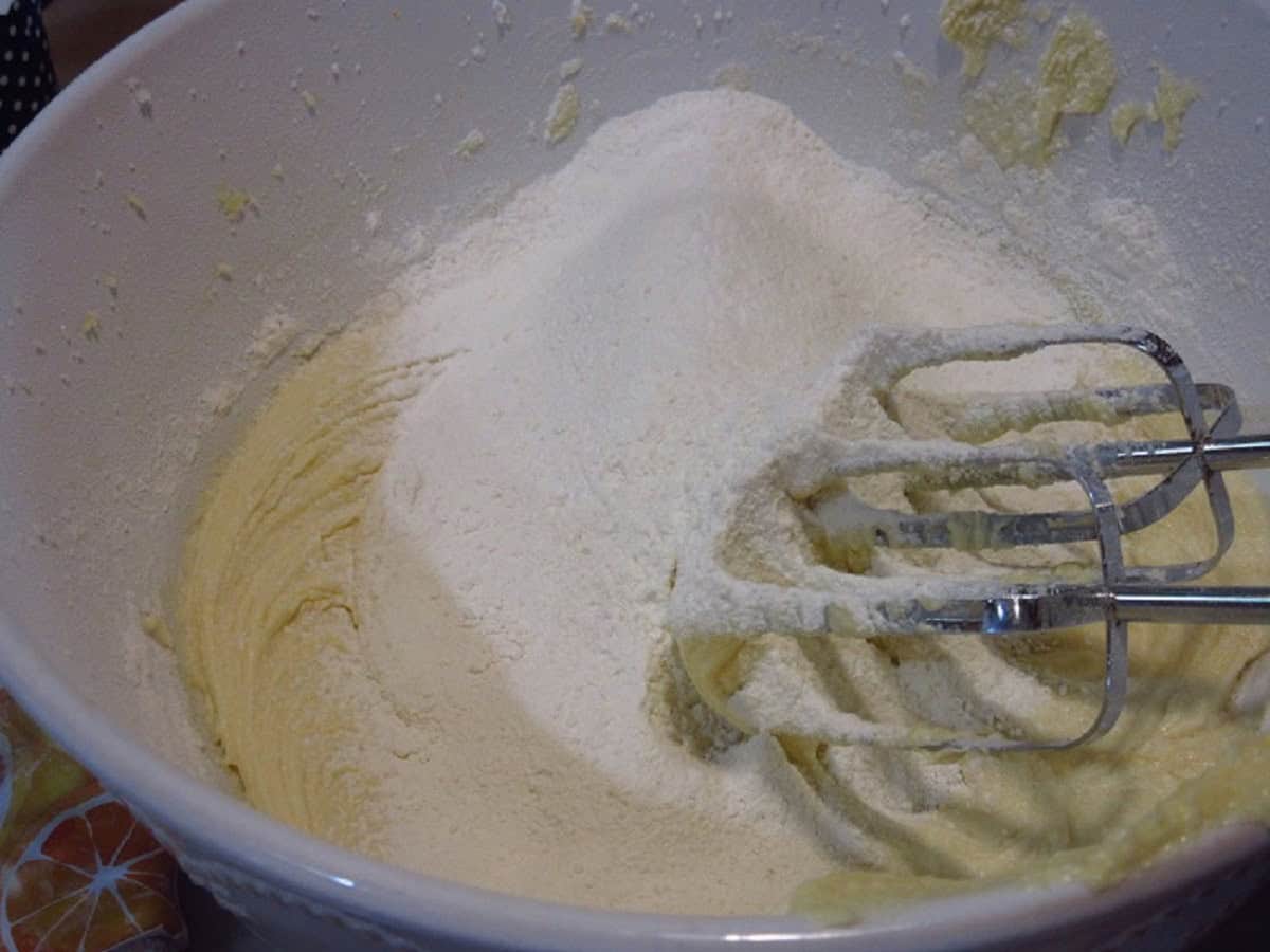 Flour and batter in a bowl with hand mixer beaters.