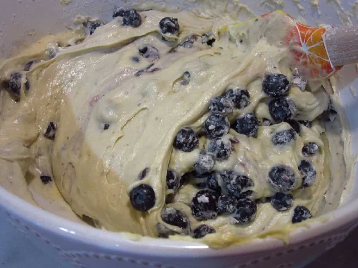 A blueberry muffin batter in a white bowl.