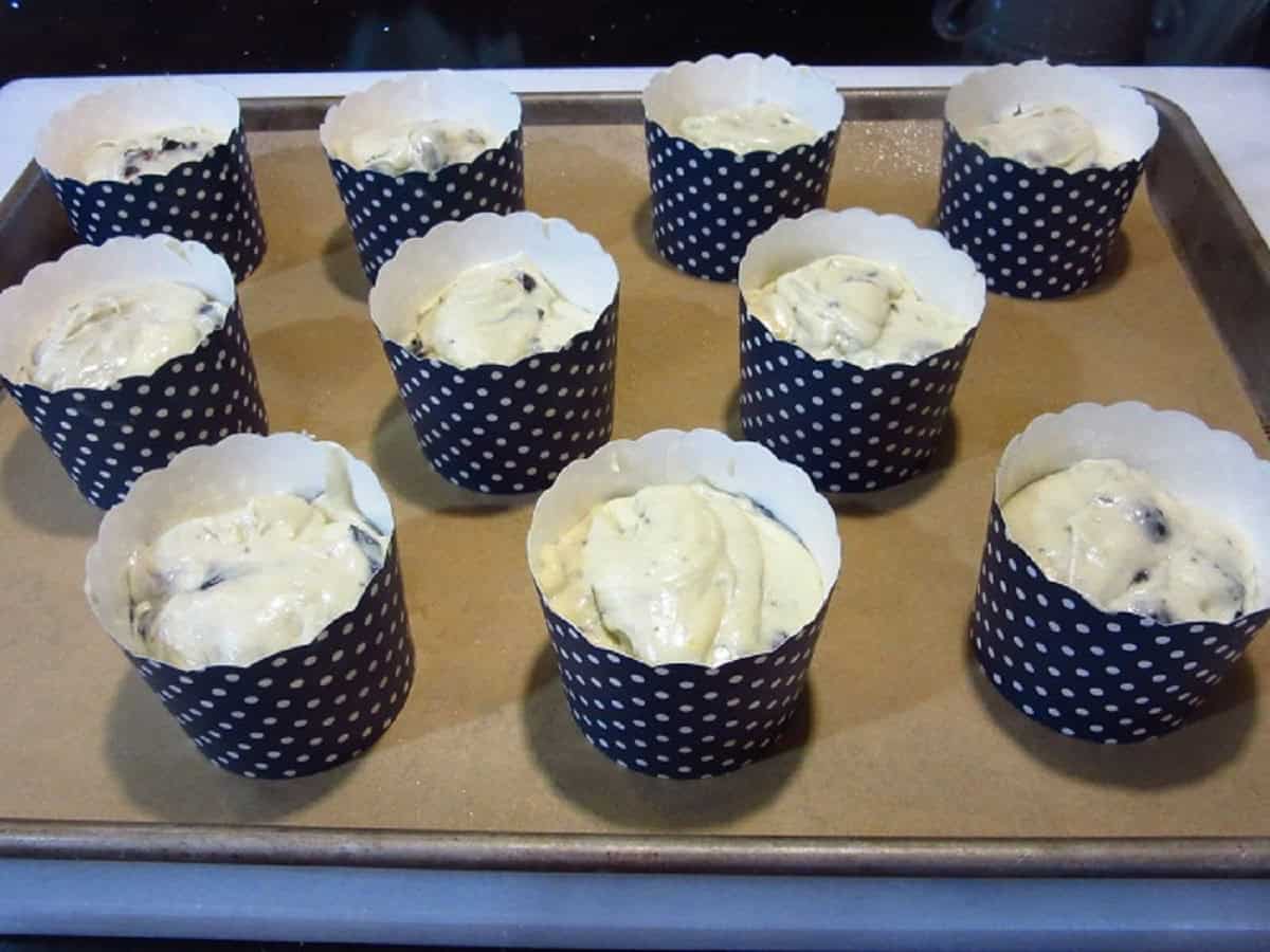 Muffin batter in blue and white polka dot muffin cups.
