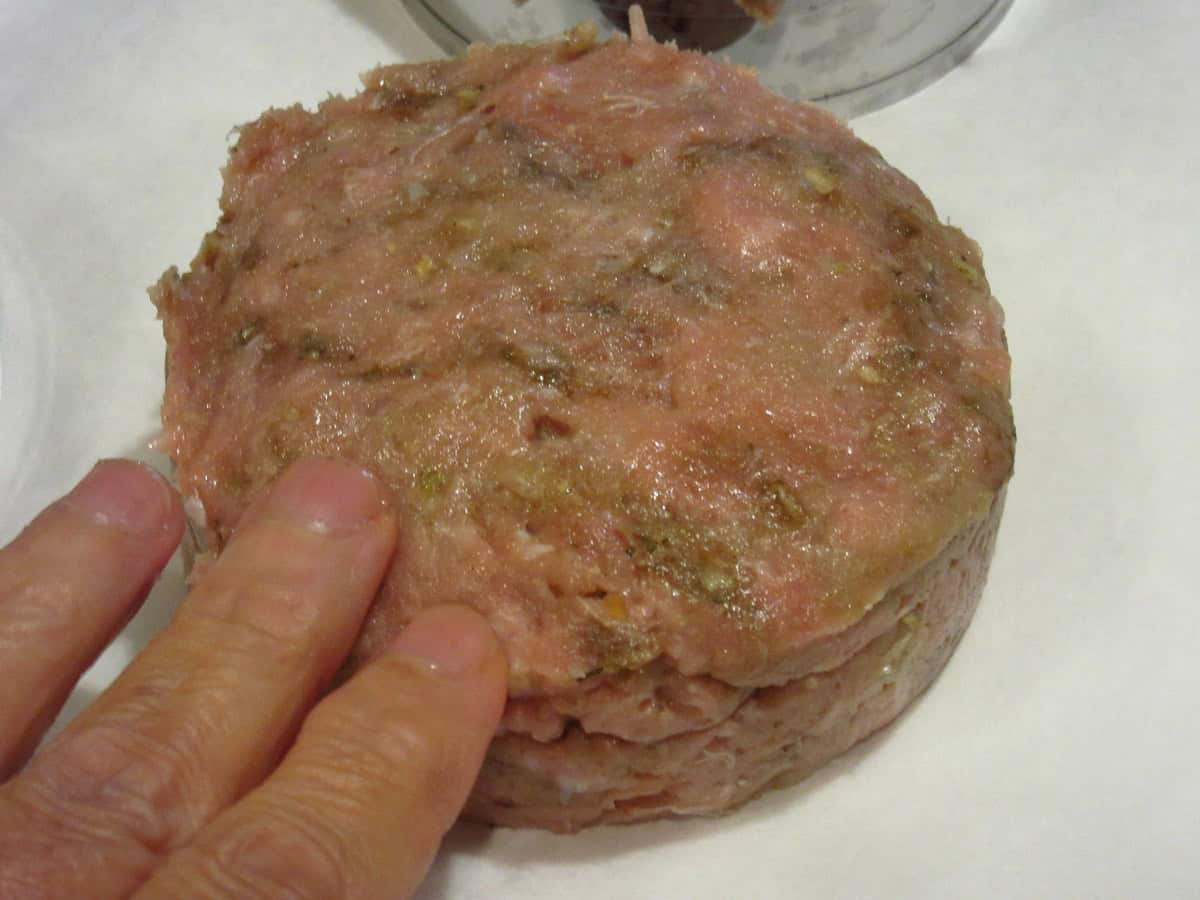 A raw stuffed turkey burger on a white countertop.