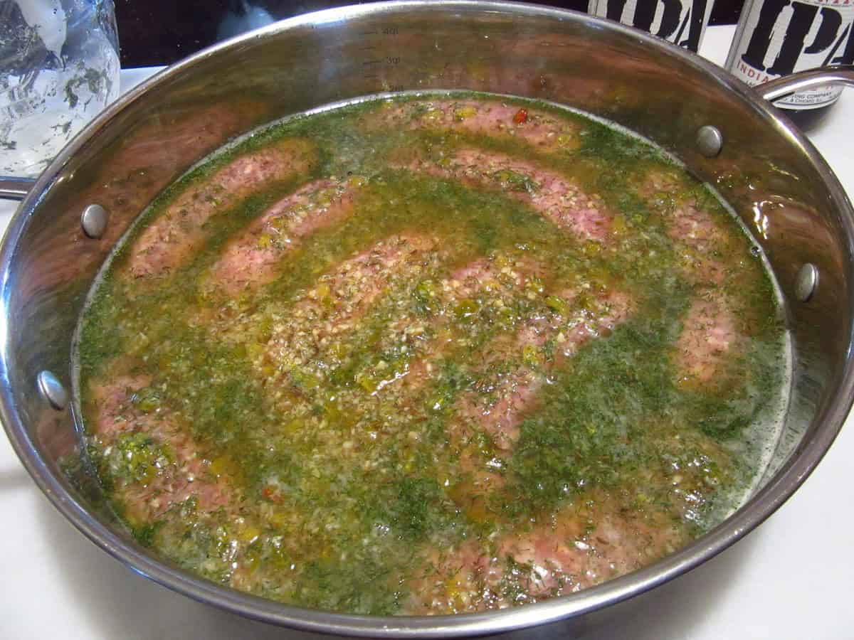 Dill weed in beer with brats in a skillet.