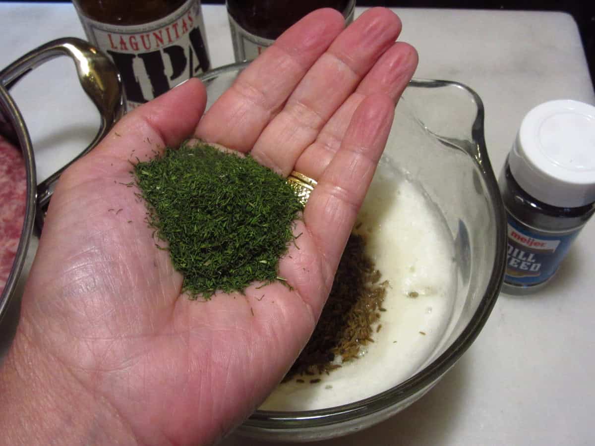 A hand holding a palmful of dill weed.