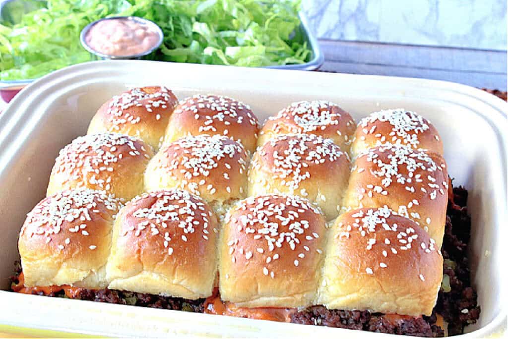 A casserole dish filled with Big Mac Sliders with sesame seed buns.