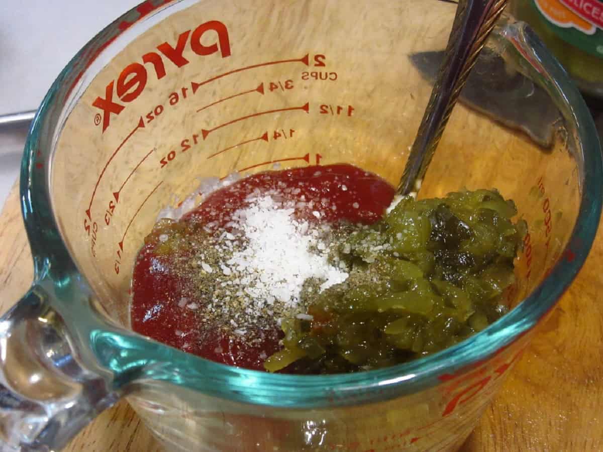 Ketchup, relish, and salt in a glass measuring cup.
