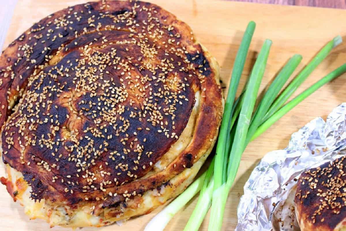A round loaf of Chinese Bing Bread topped with sesame seeds.