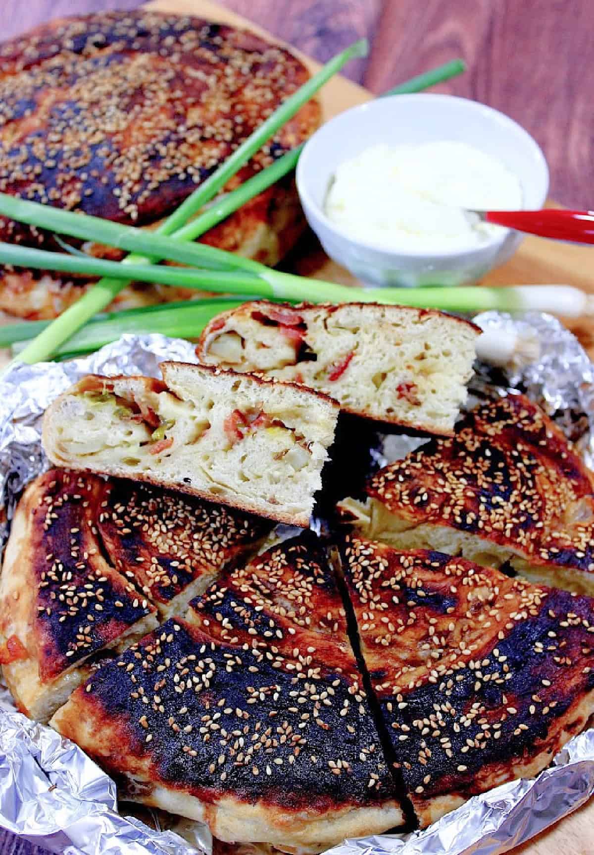 Bing Bread is a yeasted sweet and savory Chinese flat bread that's filled with potato, bacon, green onion and cheese. A golden brown, round loaf of Chinese Bing Bread filled with bacon and scallions.