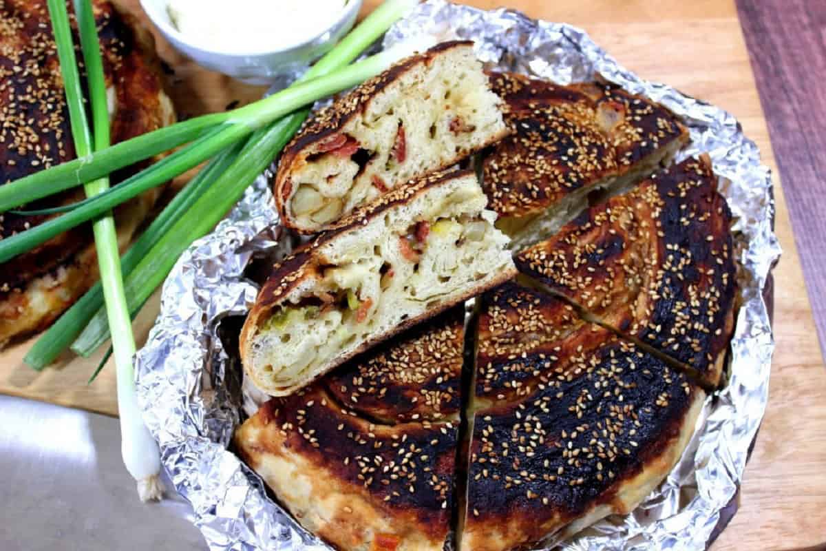 A loaf of Chinese Bing Bread on foil with a slice cut out.
