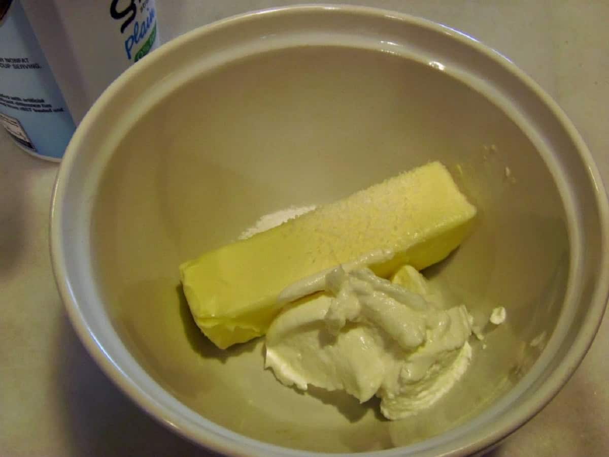 Softened butter and sour cream in a small white bowl.