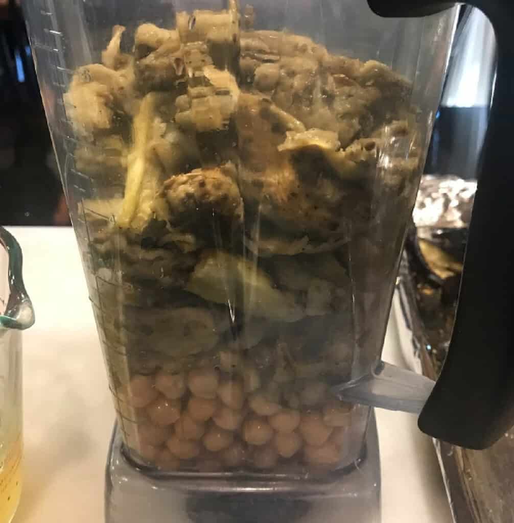 A Vitamix blender layered with chickpeas and roasted eggplant to make hummus.