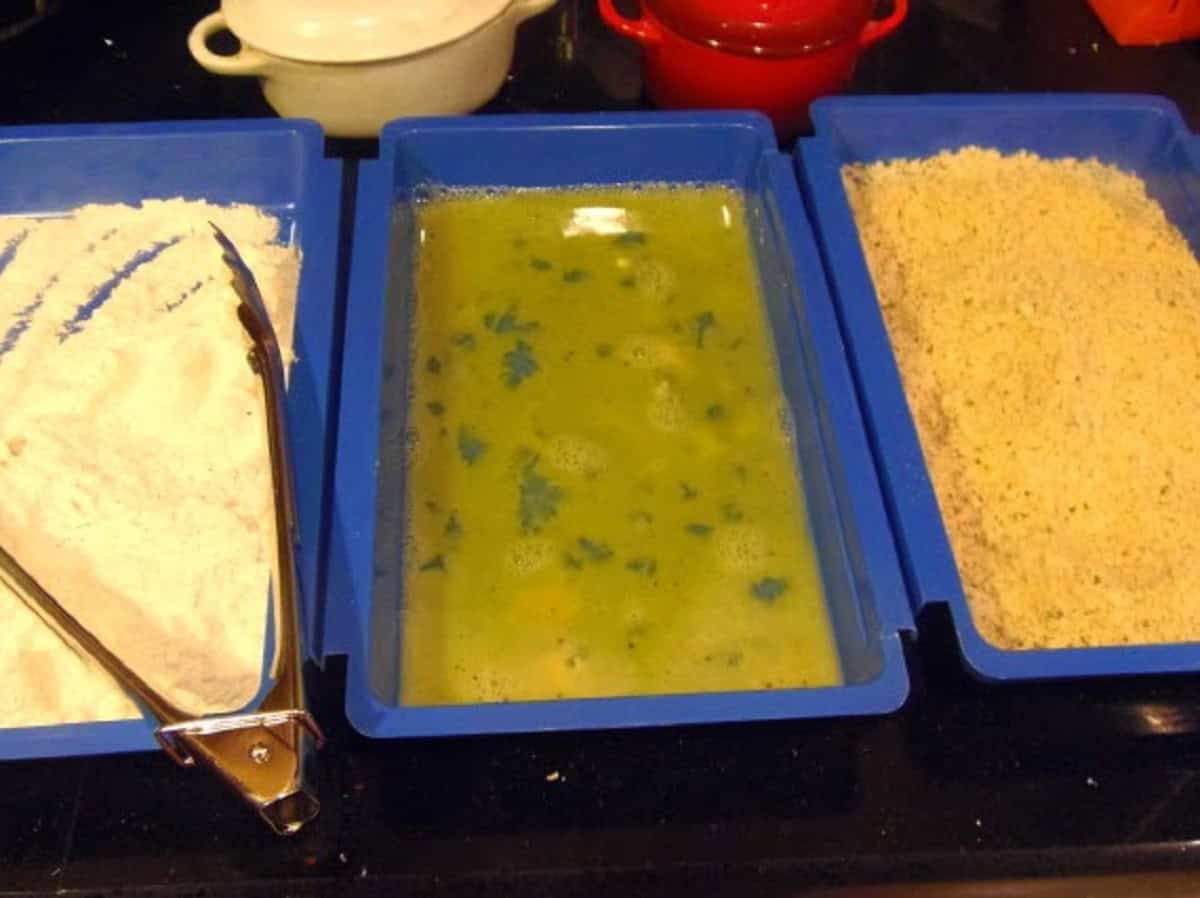 A three station breading station for making pork schnitzel.