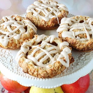 Apple blossoms drizzled with vanilla glaze on a cake stand.