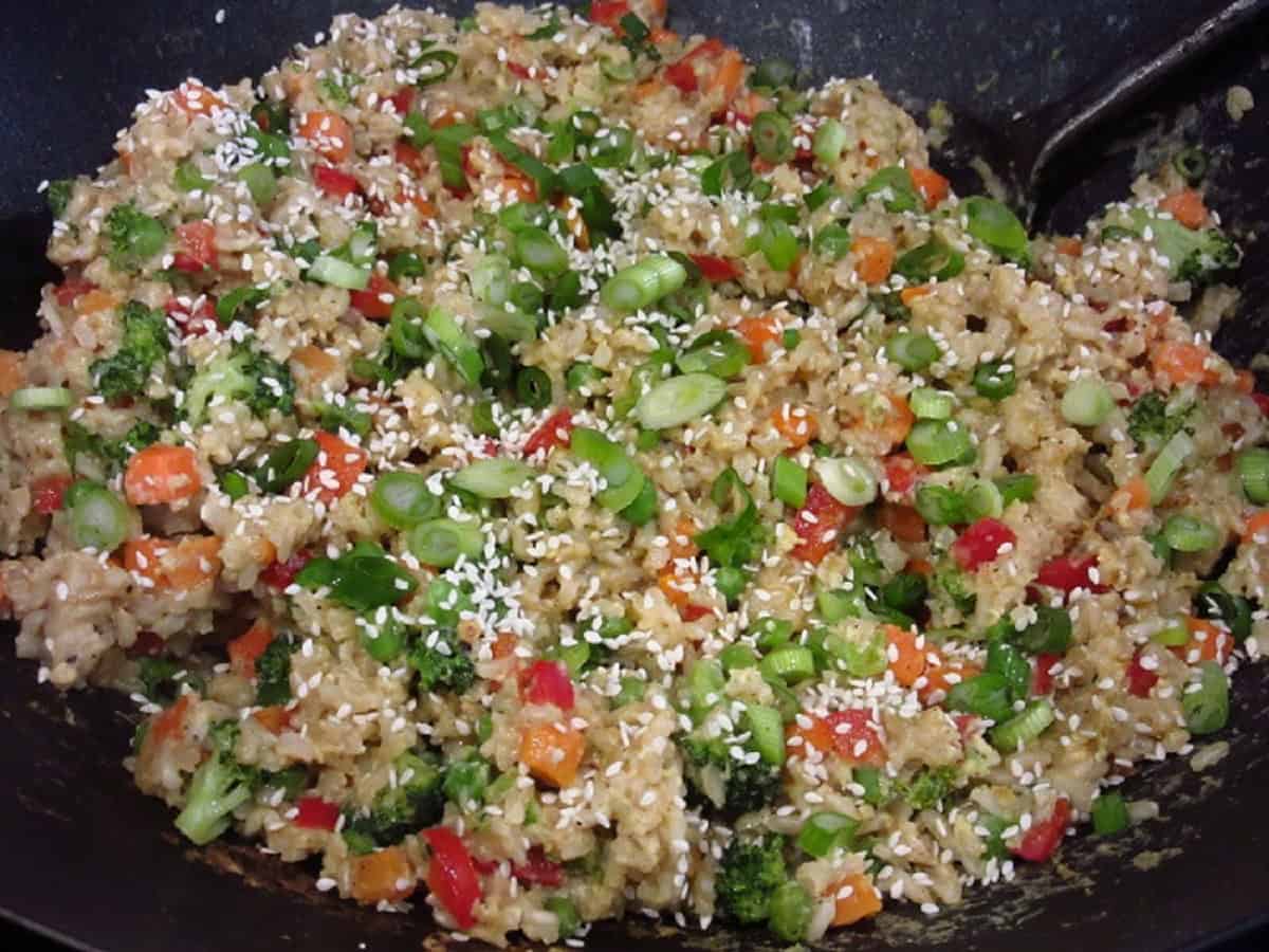 A colorful completed dish of stir-fried brown rice in a wok.